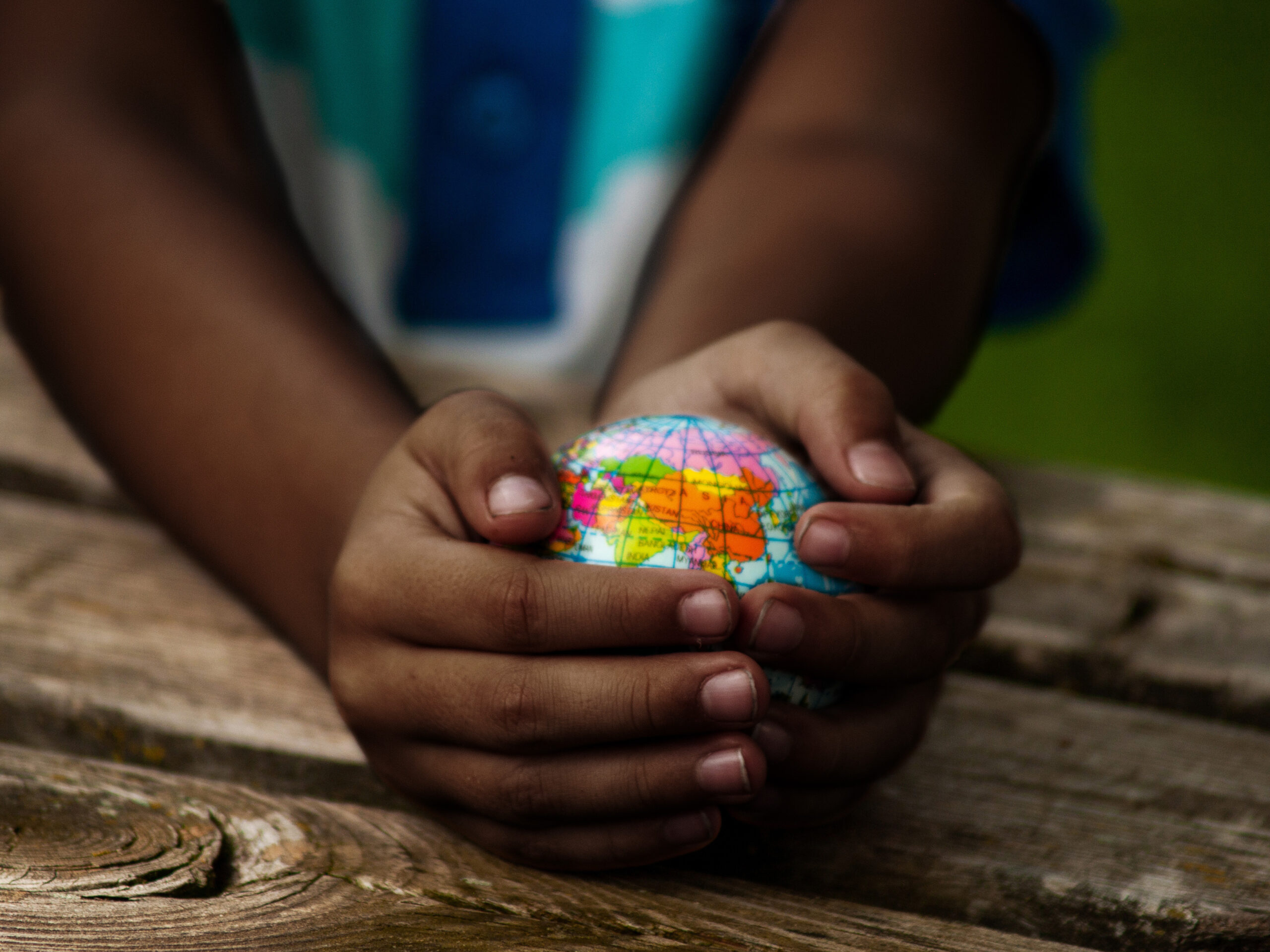 A small child holds a globe in their hands