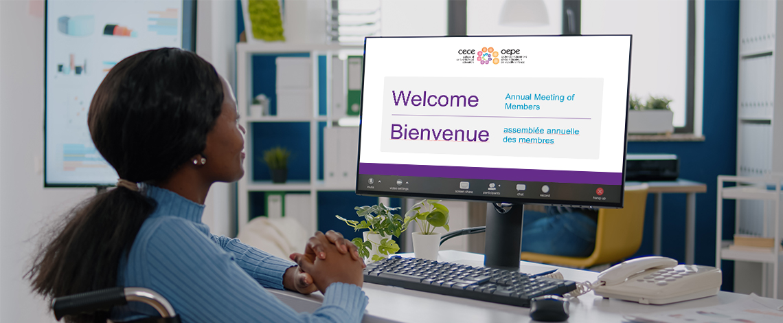Woman looking at her computer monitor. Screen displays words “Welcome. Bienvenue”