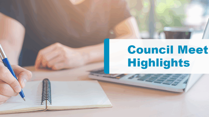 Person taking notes on a notebook with laptop in front. Text displays “Council Meeting Highlights.”